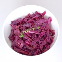 Braised Red Cabbage and Apples with Maple & Thyme is a pretty and delicious side dish to add to your plate. Red cabbage and apples are braised with maple syrup, cider vinegar, mustard, and thyme for a sweet and savory combination that highlights some of the most popular flavors of the fall and winter season. #Vegan #GlutenFree