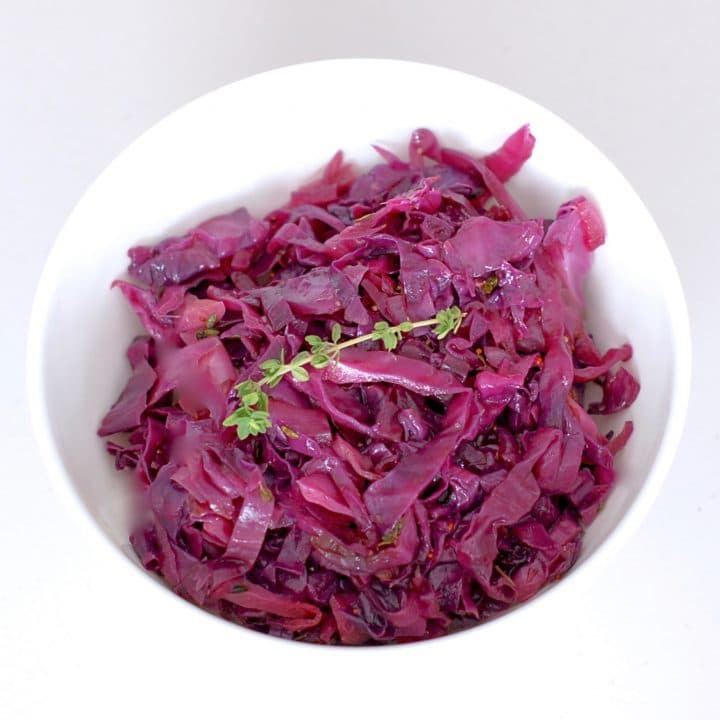 Braised Red Cabbage and Apples with Maple & Thyme is a pretty and delicious side dish to add to your plate. Red cabbage and apples are braised with maple syrup, cider vinegar, mustard, and thyme for a sweet and savory combination that highlights some of the most popular flavors of the fall and winter season. #Vegan #GlutenFree