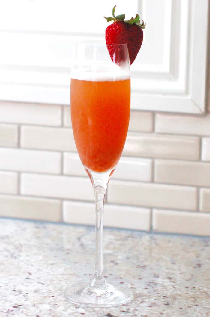 Strawberry Rhubarb Mimosa in Champagne flute with strawberry on rim