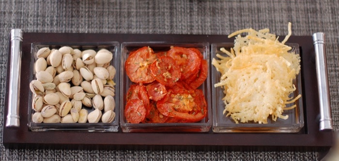 snack platter with pistachios, roasted tomatoes, and cheese crisps