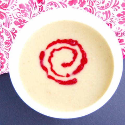 bowl of parsnip pear soup with cranberry coulis
