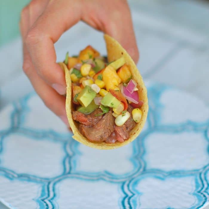 Hand grabbing Soy-Marinated Steak Tacos