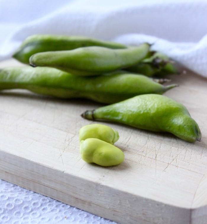 Fresh Fava Beans in pods on cutting board