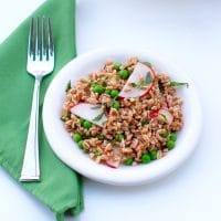 Nutty farro, crunchy radishes, and sweet peas are tossed together in a tart lemon mint dressing in this bright Spring Pea and Radish Farro Salad! #vegan #nutfree #springrecipes #farro #wholegrains
