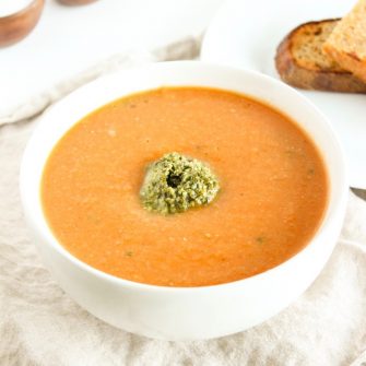 Warm up this fall and winter with a bowl of tomato white bean soup topped off with a dollop of kale pesto. Gluten free, vegetarian, and vegan-friendly.