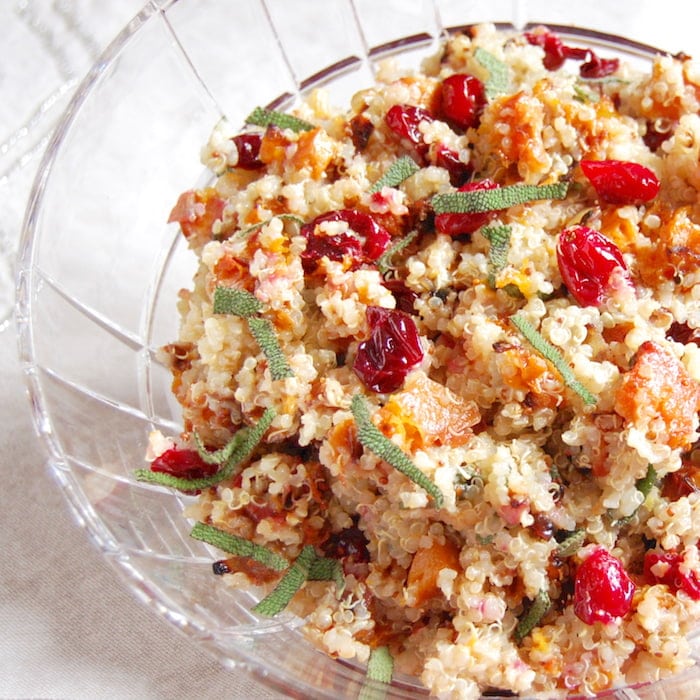 close up of roasted butternut squash and cranberry quinoa salad topped with sage and pecans