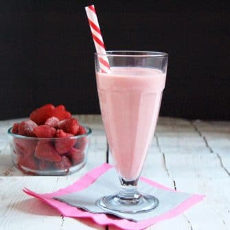 strawberry kefir smoothie in tall glass with straw