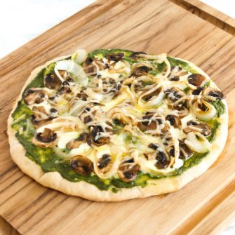 Mushroom Pesto Pizza | Sautéed mushrooms, nut-free kale pesto, fresh mozzarella and a drizzle of truffle oil pair beautifully in this gourmet homemade pizza. Get the vegetarian and nut-free recipe @jlevinsonrd.