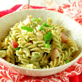 Whole grain pasta is tossed with peas, roasted radishes, and a nut-free mint and radish greens pesto in this light and delicious spring pasta dish. #vegetarian #nutfree #glutenfreefriendly #pesto #springrecipes #mint #pasta