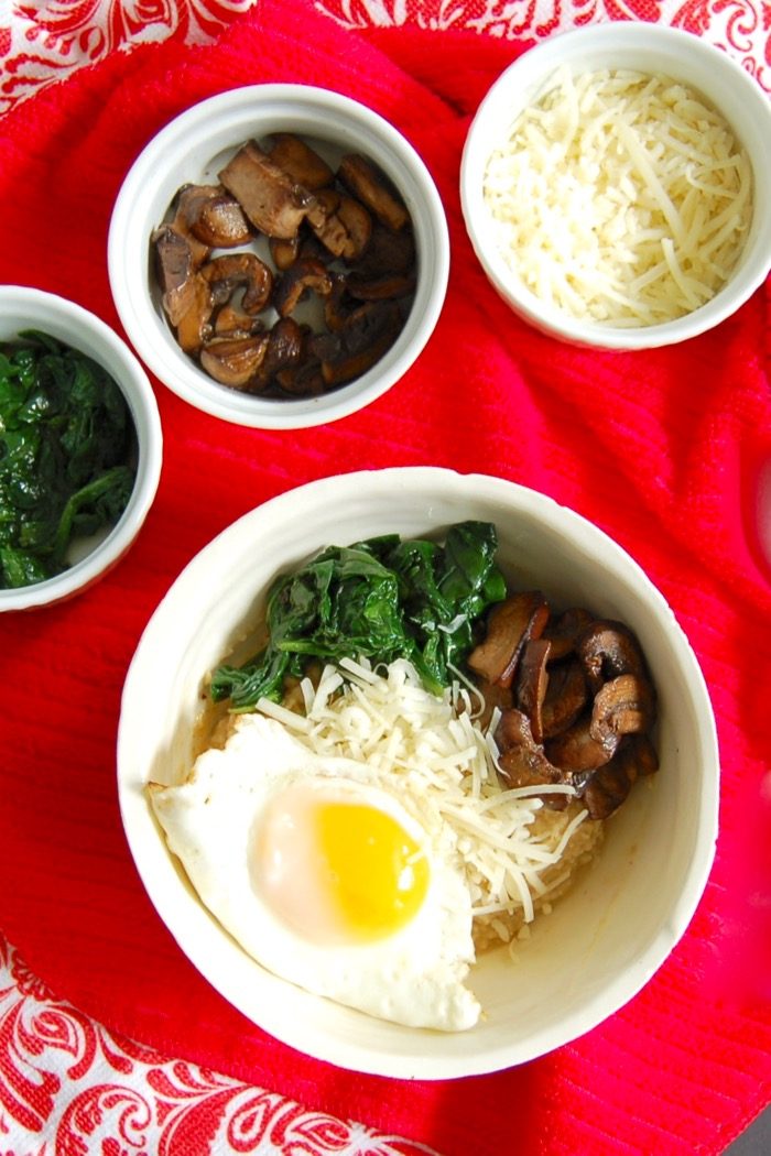 savory oatmeal bowl with mushrooms, spinach, cheese, and fried egg