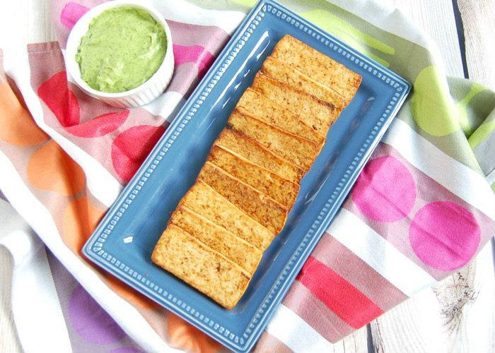 Grilled Tofu on blue serving plate with avocado sauce in ramekin on side